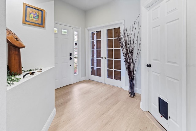 entrance foyer with light hardwood / wood-style floors, french doors, and a healthy amount of sunlight