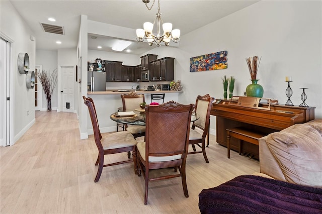 dining room with a chandelier and light hardwood / wood-style flooring