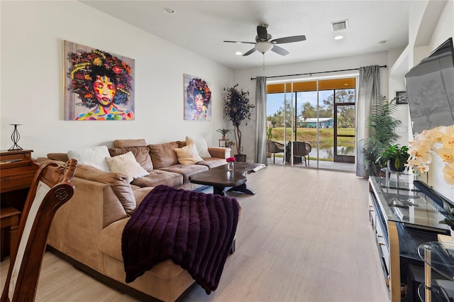 living room with light hardwood / wood-style floors and ceiling fan