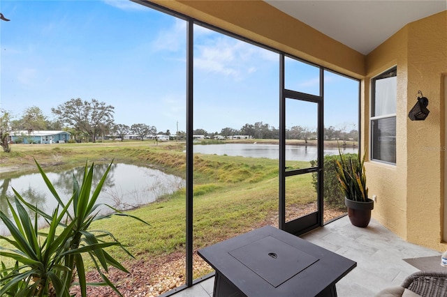 sunroom / solarium featuring a water view