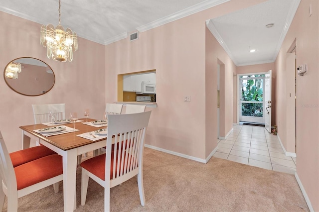 carpeted dining room featuring ornamental molding and an inviting chandelier