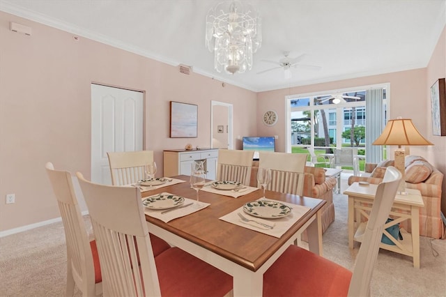 dining area featuring crown molding, ceiling fan with notable chandelier, and light colored carpet