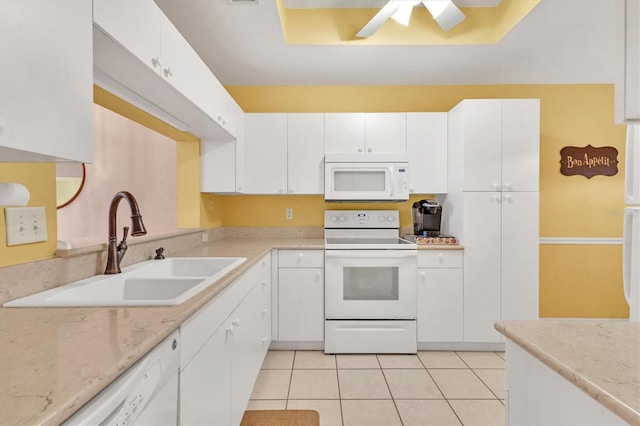 kitchen featuring white appliances, light tile patterned floors, sink, and white cabinets