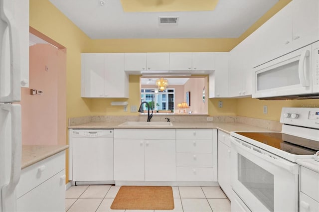 kitchen featuring white cabinetry, sink, light tile patterned floors, and white appliances