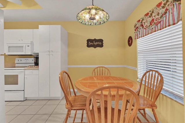 dining area with light tile patterned floors and a notable chandelier