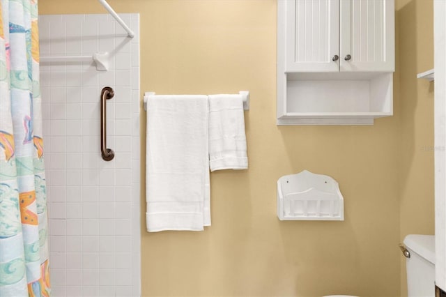 bathroom with curtained shower and toilet