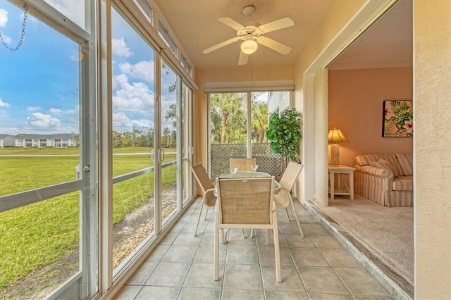 unfurnished sunroom featuring ceiling fan and a wealth of natural light