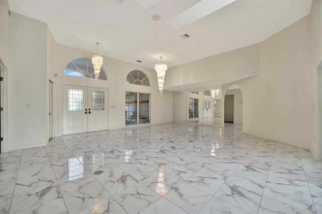 foyer entrance featuring an inviting chandelier and french doors