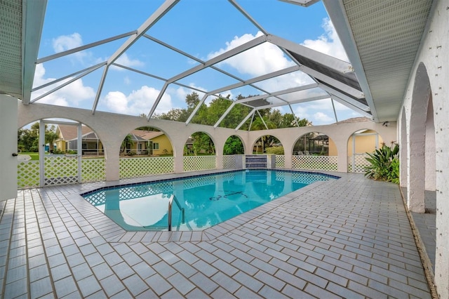 view of pool with glass enclosure and a patio area