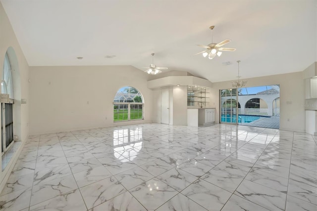 unfurnished living room with lofted ceiling and ceiling fan with notable chandelier