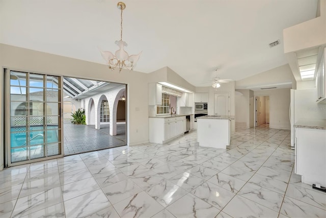 kitchen with stainless steel appliances, sink, white cabinets, and decorative light fixtures