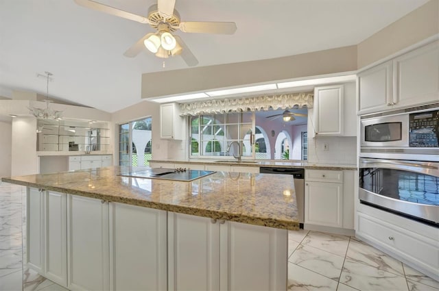 kitchen featuring white cabinetry, appliances with stainless steel finishes, light stone counters, and backsplash