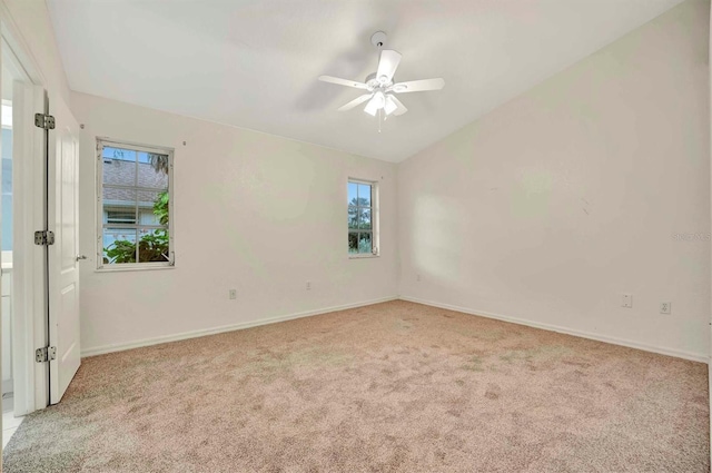 carpeted empty room featuring vaulted ceiling and ceiling fan