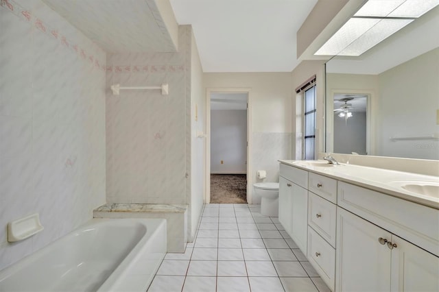 bathroom featuring a skylight, tile walls, tile patterned flooring, vanity, and toilet