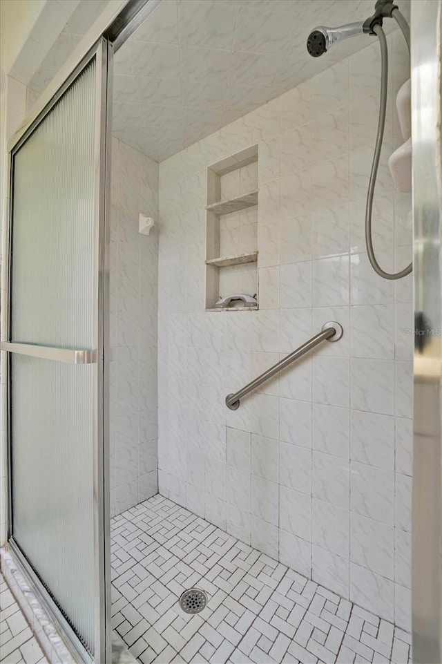 bathroom featuring a shower with shower door