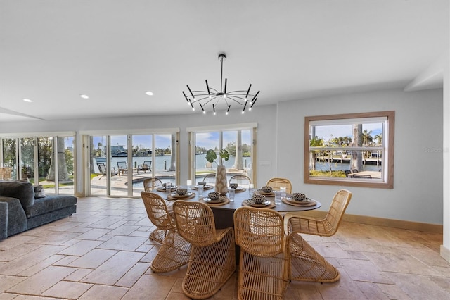 dining room featuring an inviting chandelier and a water view