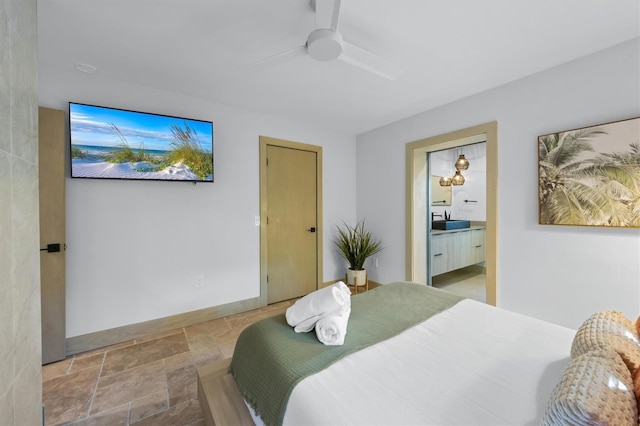 bedroom with ceiling fan, connected bathroom, and sink