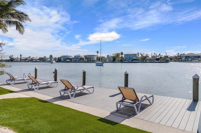 dock area with a lawn and a water view