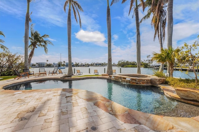 view of swimming pool featuring an in ground hot tub, a water view, and a patio