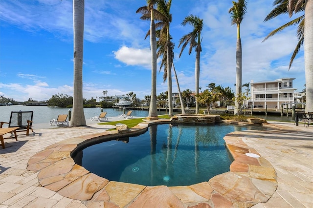 view of pool with an in ground hot tub, a patio, and a water view