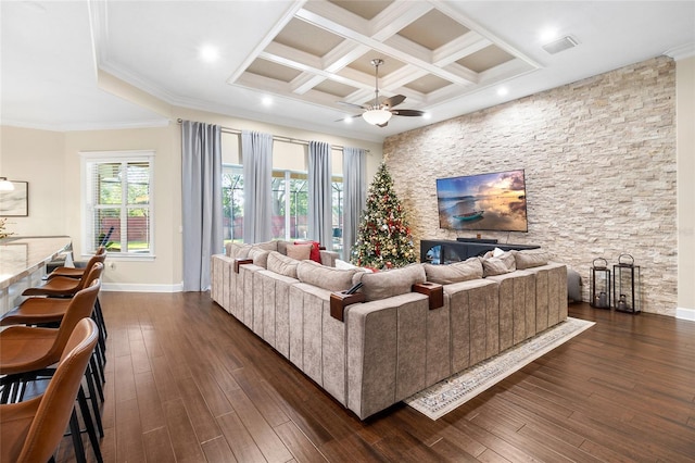 living room featuring coffered ceiling, beam ceiling, ornamental molding, dark wood-type flooring, and ceiling fan