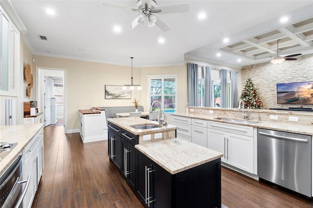 kitchen with white cabinetry, sink, pendant lighting, stainless steel appliances, and a center island with sink