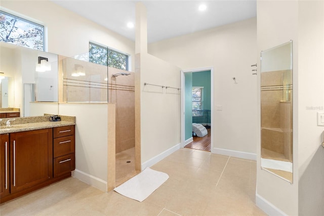 bathroom with tile patterned floors, tiled shower, and a healthy amount of sunlight