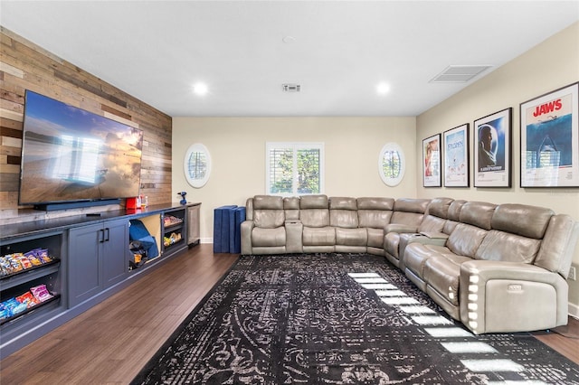 living room featuring dark wood-type flooring and wooden walls