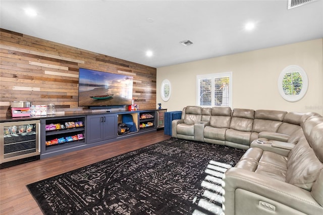 living room featuring wooden walls, wine cooler, and dark hardwood / wood-style flooring