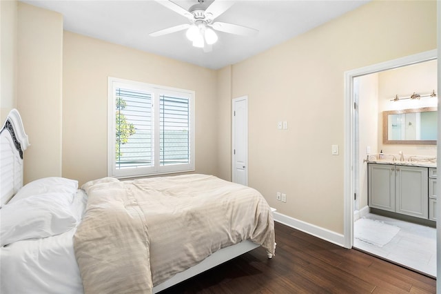 bedroom featuring ceiling fan, dark wood-type flooring, ensuite bathroom, and sink