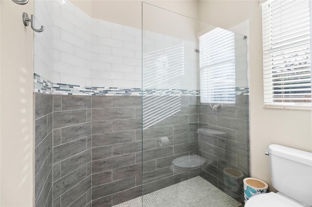 bathroom with toilet and a tile shower