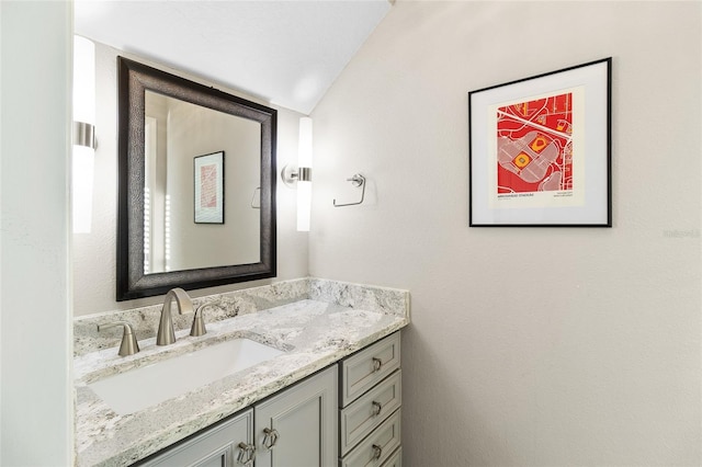 bathroom with vanity and lofted ceiling