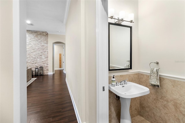 bathroom featuring sink, ornamental molding, and wood-type flooring