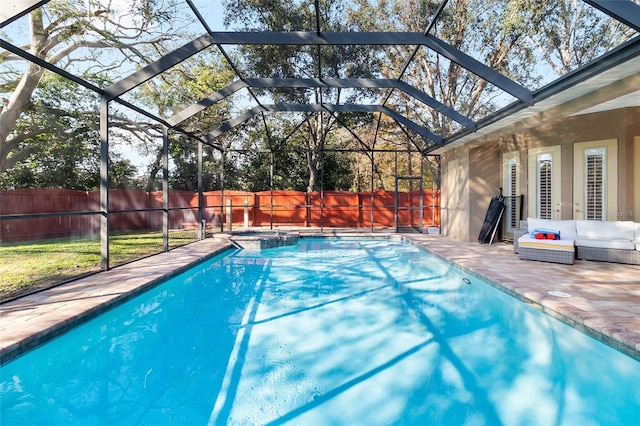 view of swimming pool with glass enclosure and a patio area