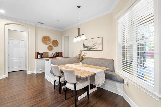 dining area with breakfast area, dark hardwood / wood-style flooring, ornamental molding, and a notable chandelier