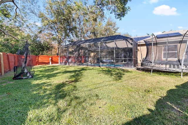 view of yard featuring a lanai and a trampoline