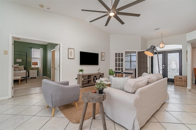 tiled living room featuring vaulted ceiling, french doors, and ceiling fan