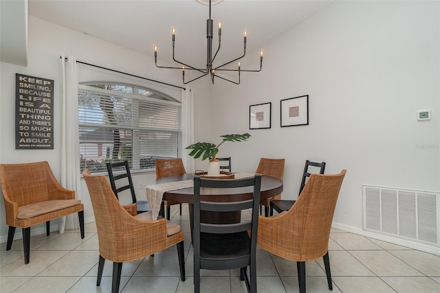 tiled dining room with an inviting chandelier