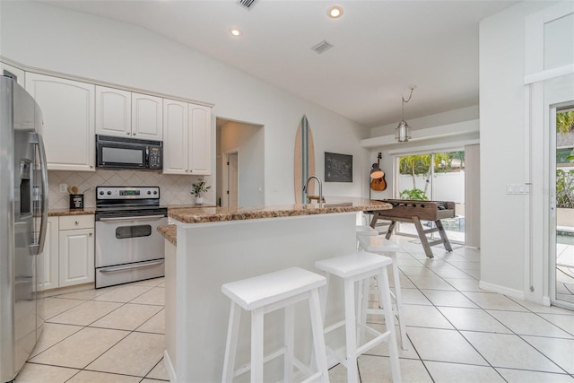 kitchen with light tile patterned floors, white cabinets, backsplash, and appliances with stainless steel finishes