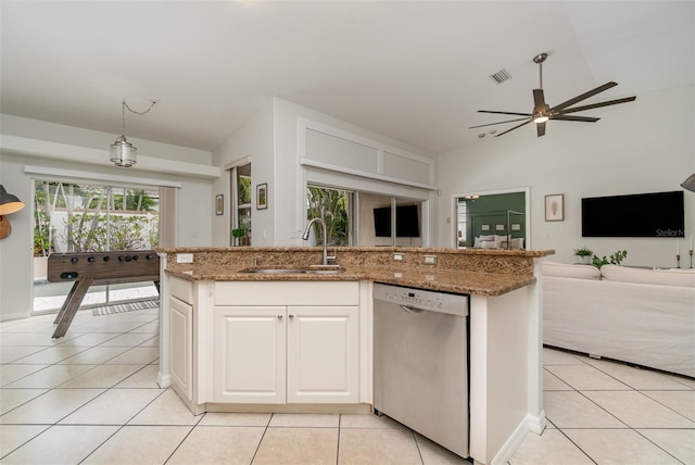 kitchen with dishwasher, sink, white cabinets, light tile patterned floors, and a center island with sink