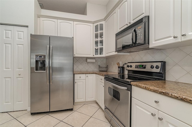 kitchen with light stone counters, white cabinets, appliances with stainless steel finishes, and light tile patterned flooring