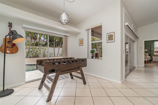 rec room with vaulted ceiling and light tile patterned floors