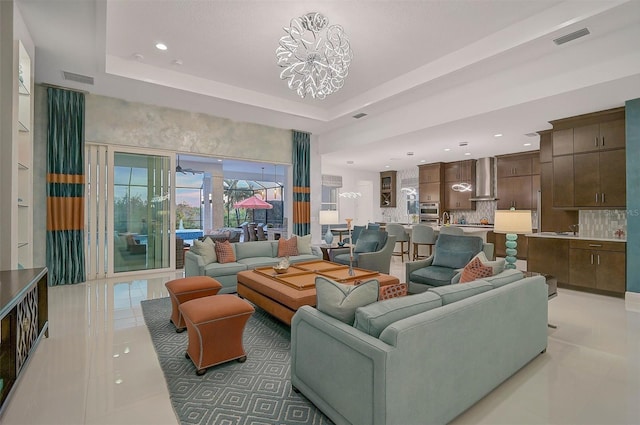 tiled living room featuring a tray ceiling, visible vents, and recessed lighting