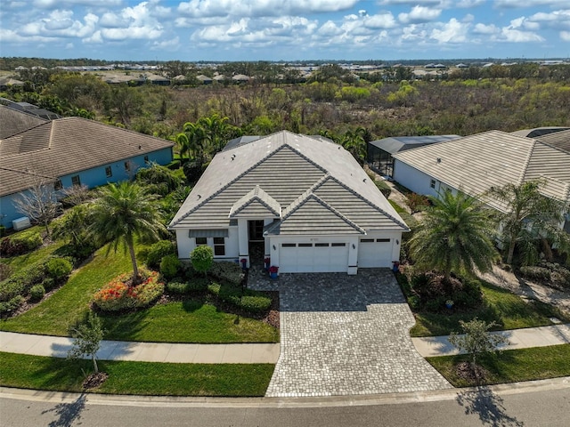 view of front of house featuring a garage, a tile roof, and decorative driveway