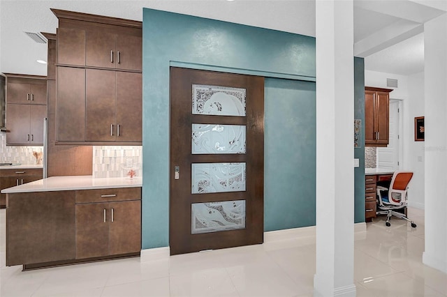 interior space featuring visible vents, light countertops, backsplash, and dark brown cabinets