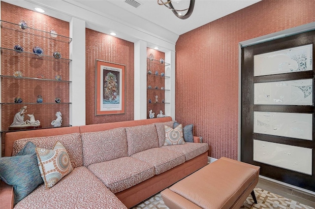 living area featuring built in shelves and visible vents