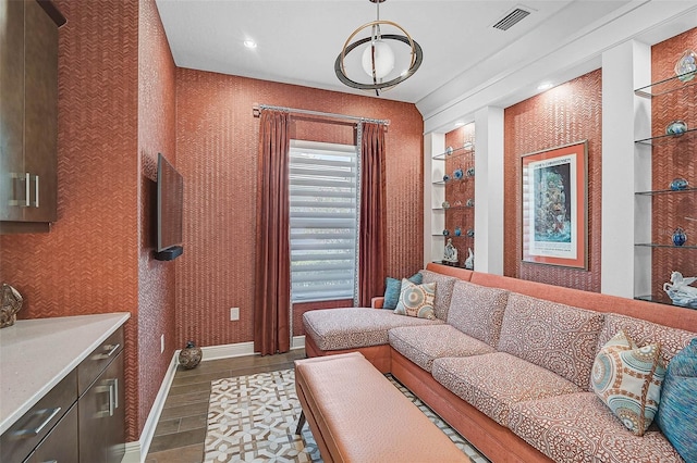 living area featuring baseboards, wood finished floors, visible vents, and wallpapered walls