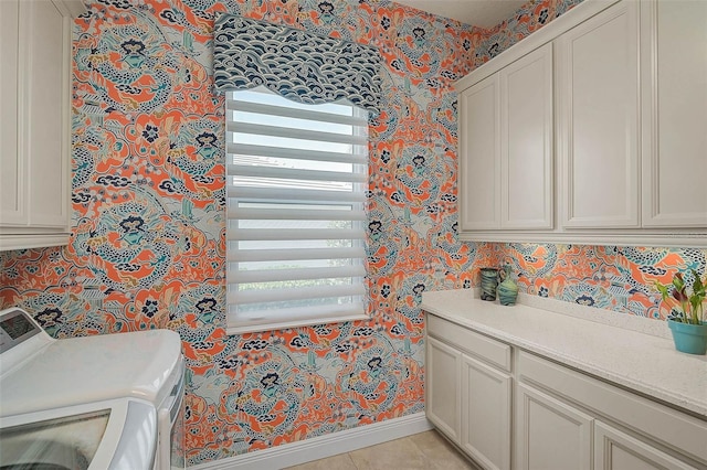 washroom with washer and clothes dryer, light tile patterned floors, cabinet space, baseboards, and wallpapered walls