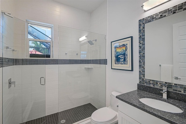 full bath featuring tasteful backsplash, a stall shower, vanity, and toilet