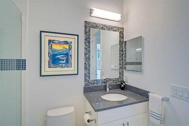 bathroom with toilet, decorative backsplash, and vanity